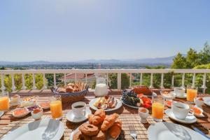雅典珀丽提亚别墅的阳台上的早餐桌,包括食物和饮料