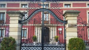 Villanueva de la PeñaPosada Santa Eulalia的一座红色的大建筑,设有黑色的大门