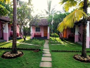 曼德姆阿瓦隆住宿加早餐旅馆的棕榈树粉色房子前面的走道