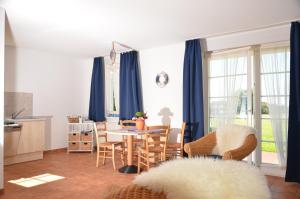 耐德西茨Ferienwohnung Landtraum的厨房以及带蓝窗帘和桌子的用餐室