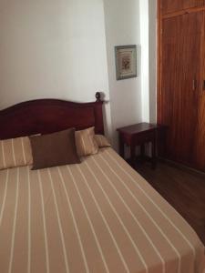 马德拉港Apartamento Mesa del Mar的一间卧室配有一张大床和木制床头板
