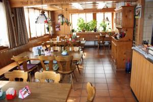 霍伊瑟恩莫斯考宜-盖特恩特亦池酒店餐厅的餐厅设有木桌、椅子和窗户。