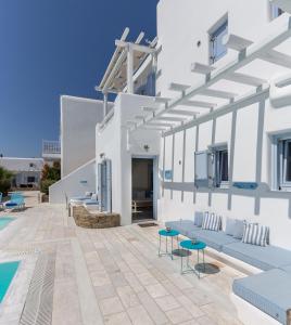 奥诺斯Verano Mykonos Villa的白色的别墅,设有游泳池和庭院