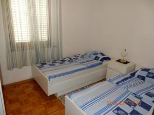 兹曼Apartments Mandolina - Hiša na samem s pogledom na morje的一间卧室设有两张床和窗户。