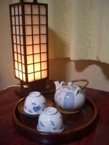 广岛春日旅馆的一张桌子,上面有两个茶壶和一盏灯
