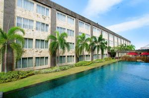 登巴萨ASTON Denpasar Hotel & Convention的建筑前的一座带游泳池的建筑