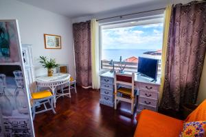 卡尼索Vista Oceano II的客房设有书桌、电脑和窗户