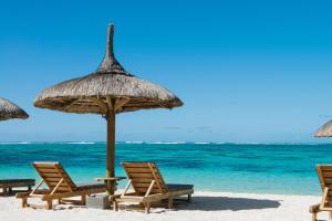 托舵道斯快乐周五酒店的海滩上的一组椅子和遮阳伞