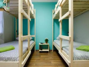 克拉斯诺亚尔斯克沃兹度旅舍的蓝色墙壁的客房内设有两张双层床。