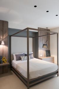 斯塔夫罗斯Fani Luxury Apartments Stavros的卧室配有带白色床单的天蓬床