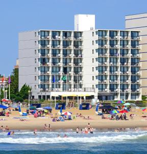 弗吉尼亚海滩海角酒店的一群人住在海滩上,有一座大建筑