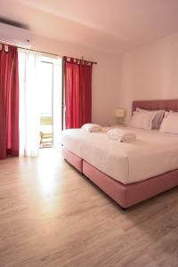 卡斯卡伊斯Suites Apartments的一间卧室配有一张带红色窗帘的大床