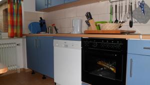 韦斯特尔斯特德Ferienwohnung_Beethovenstrasse的厨房配有蓝色橱柜和黑色洗碗机