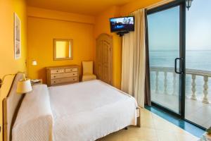 圣斯特凡诺迪卡马斯特拉Hotel La Playa Blanca的一间卧室设有一张床,阳台配有电视。