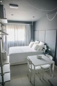 大塔拉哈尔Fuerteventura in Loft的卧室配有白色的床、桌子和桌子