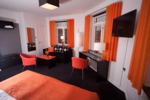 哈泽斯莱乌哈莫尼酒店的一间卧室配有橙色窗帘、一张床和一张书桌