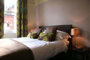 约克格利门宾馆的卧室配有带枕头的床铺和窗户。