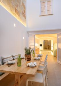 休达德亚Holiday Home Casa Sa Font by Mauter Villas的一间带木桌和白色椅子的用餐室