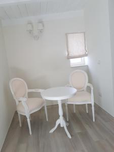 卡萨诺德莱穆尔杰Finestre sul Borgo的一张桌子和两把椅子以及一张白色的桌子和椅子