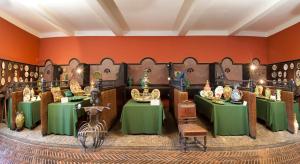 贝济耶德赖萨克城堡酒店的绿色桌椅和橙色墙壁的客房