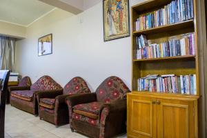 开罗卫报旅馆的一间设有三把椅子的房间和一个书架