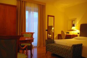 巴索维扎狄彭当斯利帕酒店的配有一张床和一张书桌的酒店客房