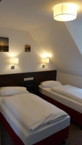 ZarrentinAppartements am Schaalsee的两张床位于带两盏灯的墙上。