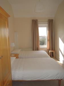 朴次茅斯Special seafront apartment的一间卧室设有两张床和窗户。