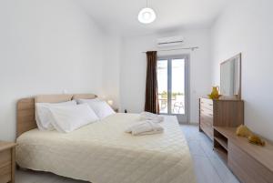 皮尔戈斯太阳景别墅酒店的白色卧室设有一张大床和一个梳妆台