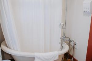 拉斐特Maison Mouton Bed & Breakfast的浴室内设有带白色淋浴帘的浴缸