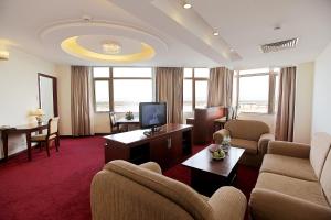 绥和市Sai Gon Phu Yen Hotel的酒店客房设有沙发、椅子和电视。