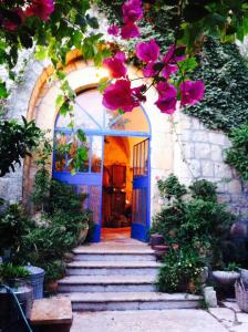 Abū GhaushMikes Khan的蓝色门和鲜花的房屋入口