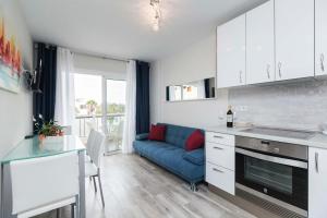 美洲海滩Apartamento El Dorado, Wi-Fi y aparcamiento gratuito的厨房以及带蓝色沙发的起居室。