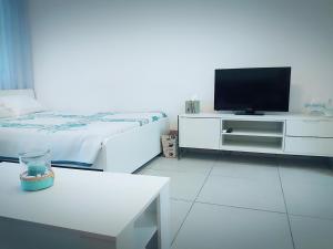 利马索尔Billis Beach Apartment的白色客房,配有电视和床