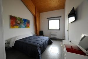阿尔塔穆拉Masseria La Meridiana的一间卧室配有一张床、一张书桌和一个窗户。