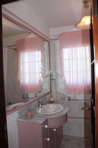 埃尔帕索Casa Gusber I的一间带水槽、镜子和粉红色的浴室 窗帘