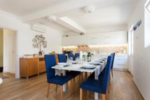 塞辛布拉Villa Branca do Castelo的一间带长桌和蓝色椅子的用餐室