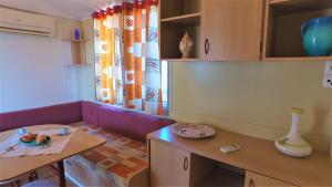 卡塔尼亚露营爱奥尼亚酒店的客厅配有紫色沙发和桌子