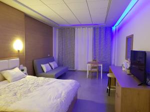 迈季代勒舍姆斯סנו נופש בגולן的酒店客房,配有一张床和紫色灯