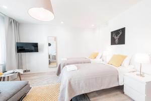 赫尔辛基Forenom Serviced Apartments Helsinki Lauttasaari的一间白色卧室,配有两张床和电视