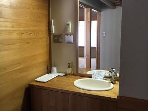 田边市龙津温泉丸井旅馆 的一间带水槽和镜子的浴室