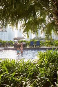 吉隆坡文华东方酒店的两名儿童在度假村的游泳池玩耍