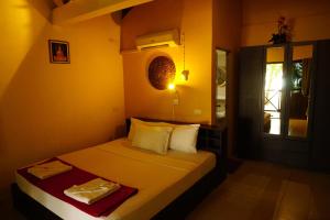 湄南海滩月亮小屋酒店的一间小卧室,配有床和窗户