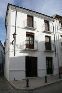 普里埃格·德·科尔多巴Casa Rural Villalta的白色的建筑,设有两个阳台和门