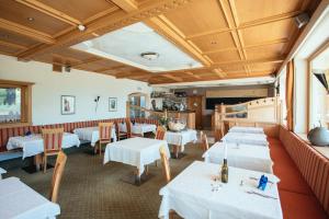 圣莱奥纳尔多因帕西里亚维德施茨酒店的一间设有白色桌椅的用餐室