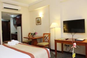 阿布扎比阿尔迪阿米娜酒店的酒店客房配有一张床、一张书桌和一台电视。