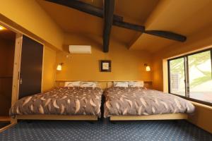 宫津市宫津萨卡拉度假屋的黄色墙壁客房的两张床