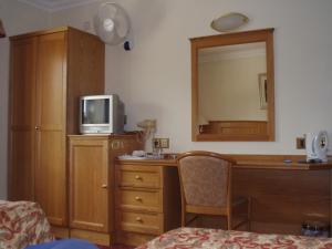 伦敦维京酒店的一间卧室配有一张桌子、一台电视和一面镜子