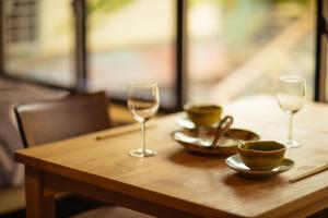 宫津市宫津萨卡拉度假屋的木桌,带两杯酒杯和碗