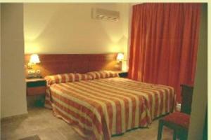 旧科尔梅纳尔艾尔齐斯康大旅馆 的酒店客房,配有床和红色窗帘